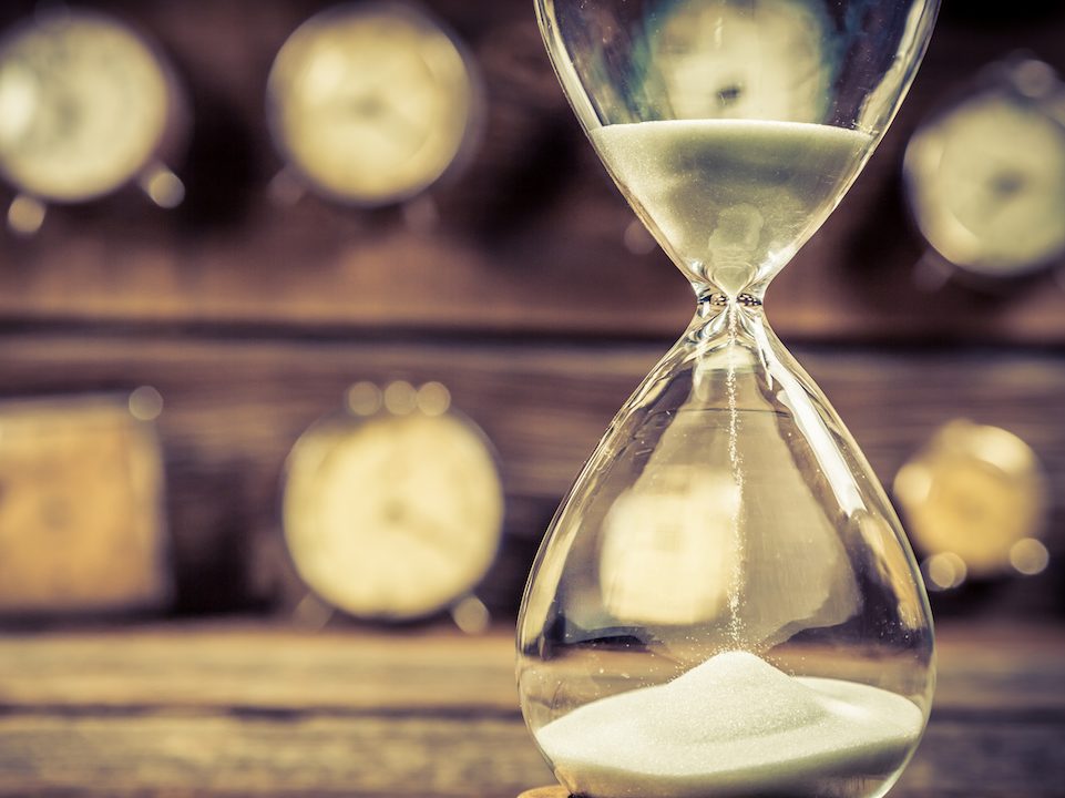 Aged hourglass with flowing sand