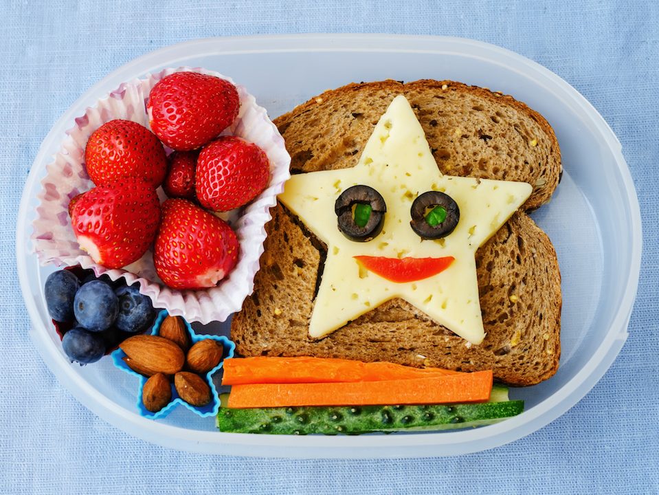school lunch box for kids with food in the form of funny faces. the toning. selective focus
