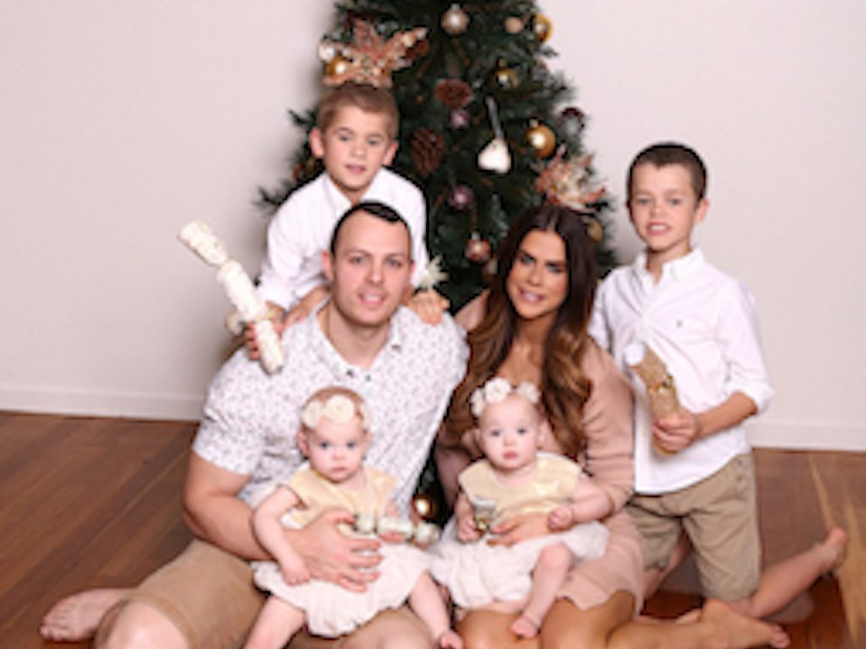 Sophie Guidolin and family sitting in front of the Christmas tree