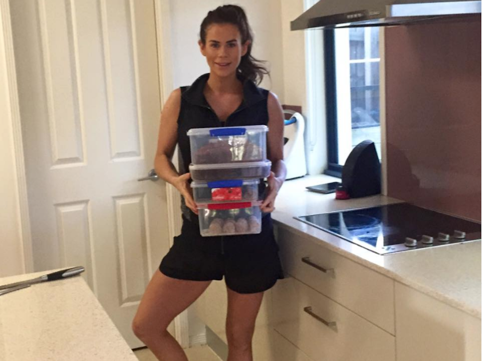 Sophie Guidolin holding meal prep in tupperware containers