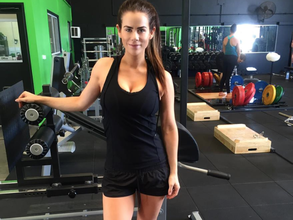 Sophie Guidolin postpartum wearing black activewear in the gym smiling
