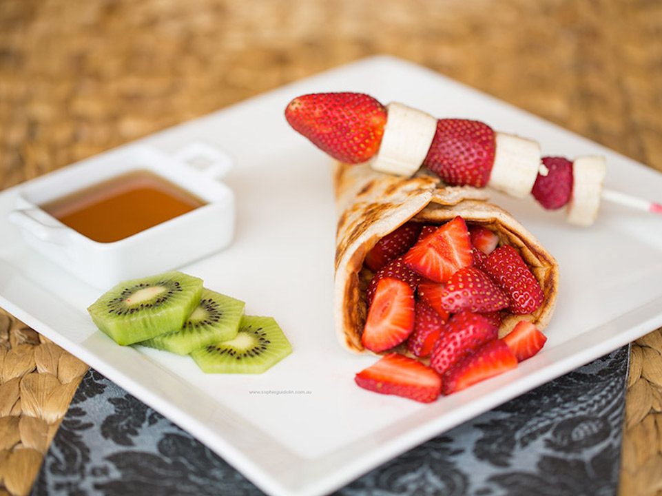Quinoa pancakes with strawberry and kiwi on a white square plate