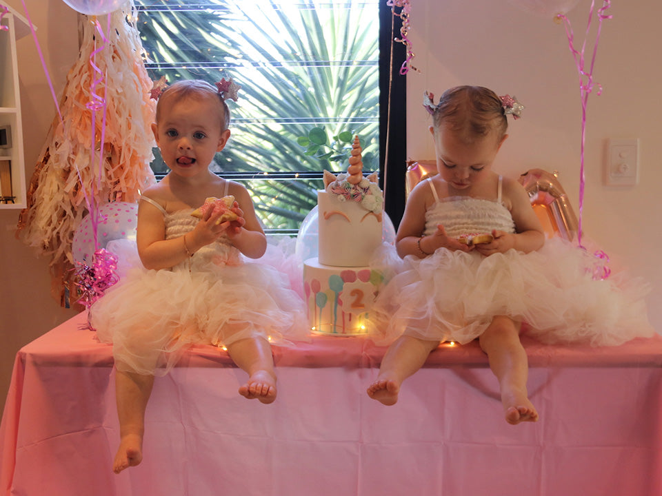 |Sophie and Nathan with the twins on their second birthday|Twins birthday with pink balloon and unicorn cake|Twin birthday cake with pink decorations|Evie and Aria's unicorn birthday cake with pink decorations|Ryder and twin at birthday party